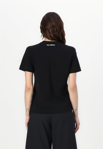 T-shirt en coton noir à manches courtes, col rond, avec un petit logo blanc "KARL LAGERFELD" au dos, texture lisse, coupe décontractée.