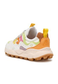 Zapatilla blanca con acentos coloridos en verde, rosa, naranja y marrón. Presenta superposiciones texturizadas, un diseño con cordones y una suela gruesa.
