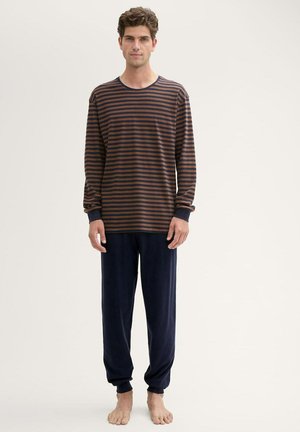 Gestreepte lange mouwen top in bruin en marineblauw, gecombineerd met marineblauwe pyjamabroek. Zachte stof met boorden en enkels trims. Casual pasvorm.