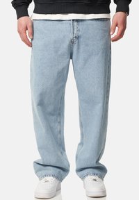 Light blue denim jeans with a loose fit, straight leg design, and subtle fading. Finished with traditional five-pocket styling and stitching details.