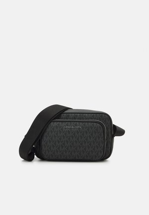 Schwarze Crossbody-Tasche mit vorderer Reißverschlusstasche und wiederholtem MK-Logo-Muster, mit verstellbarem breitem Riemen und Michael Kors Branding.