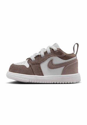 Buty sportowe Nike w rozmiarze dla malucha, z białą podeszwą, białą i brązową cholewką z zamszu, białymi sznurowadłami i brązowym logo Nike swoosh.