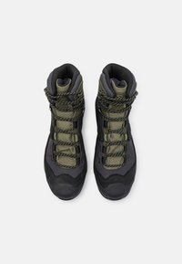 Hiking boots with a dark black and olive green design. Features textured fabric, reinforced toe caps, and patterned laces for secure fit.