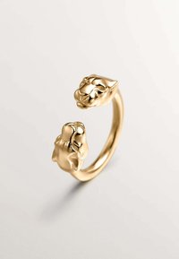 Anillo en tono dorado que presenta dos cabezas de animales estilizadas en cada extremo, superficie lisa, banda redondeada y detalles faciales intrincados.