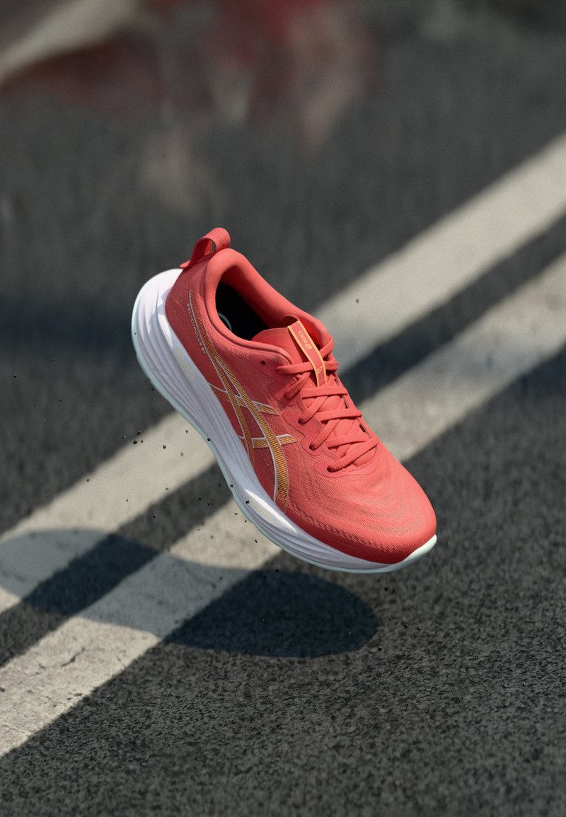 Baskets de course rouges avec un dessus texturé, semelle blanche et accents dorés. Présentent un design à lacets et une languette au talon.