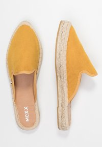 Gula mockasiner med vid öppning och vävt jute-detalj. Mjuka i texturen, med en beige sula och präglat varumärke.