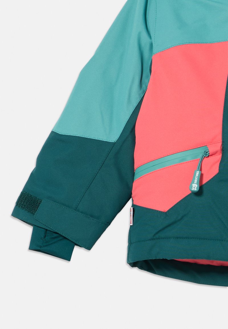 Farbblockierte Jacke mit türkisen und korallenfarbenen Abschnitten, ausgestattet mit einer Reißverschlusstasche und verstellbaren Klettverschlussärmeln. Hergestellt aus glattem, strapazierfähigem Material.