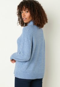 Maglione azzurro chiaro a maglia con colletto alto, maniche lunghe, polsini a coste e vestibilità comoda. Tessuto morbido e dettagli nella cucitura delle spalle.