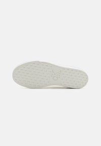 Weiße Sneaker-Sohle von Calvin Klein mit einem strukturierten Muster und einem Logo-Impressum. Glatte Oberfläche mit klarem Design, minimalistischer Stil.