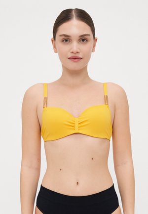Yellow bikini top with soft fabric, underwire support, gathered center, and thin straps featuring metallic accents on the shoulders.