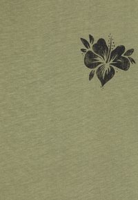 Olivovo zelená látka s mäkkou textúrou, na ktorej sa nachádza čierny kvetinový vzor, zdôrazňujúci design hibiscus s detailnými listami a akcentami.