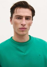 Groen sweatshirt met een ronde hals, geribbelde kraag en boorden, met een klein logo op de borst. Gestructureerde stof, casual ontwerp.