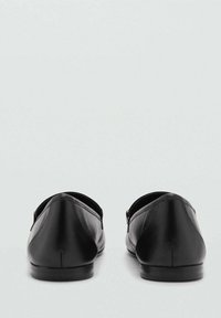 Zwarte leren ballerina's met een gladde textuur, rond neustype en lage hak. Heeft een subtiele metallic accent aan de zijkant.