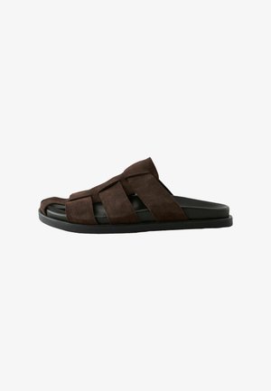 Brown suede slide sandal with wide crisscross straps and black cushioned sole, open toe and low heel for casual wear.
