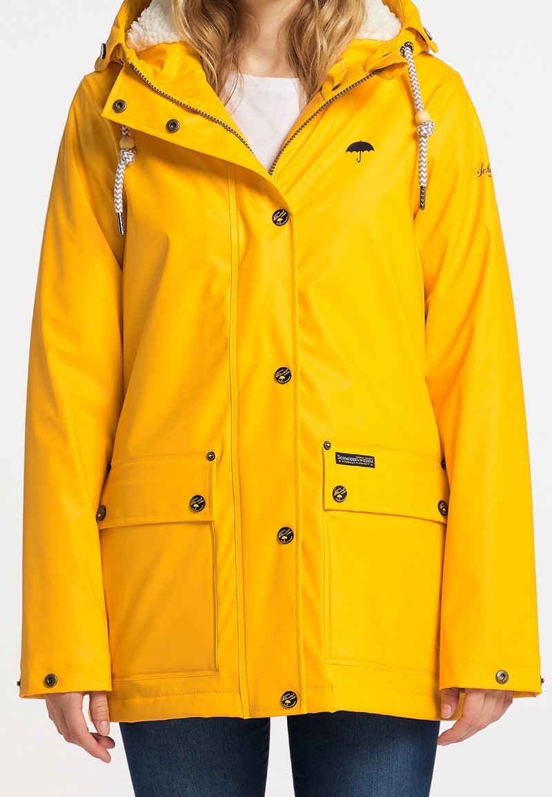 Veste imperméable jaune avec une doublure en fausse fourrure, dotée d'une capuche, de deux poches avant, de boutons-pression et d'un petit logo parapluie noir.