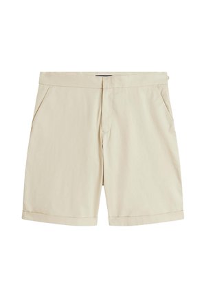 Pantalones cortos beige hasta la rodilla con un frente limpio, bolsillos laterales, trabillas para cinturón y un pequeño puño en el dobladillo.