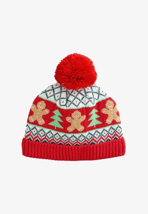 Căciulă tricotată roșie cu motive albe, verzi și aurii, cu oameni de turtă dulce și brazi de Crăciun, ornamentată cu un pom-pom roșu.