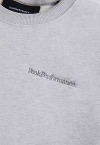 Felpa grigia in cotone con collo rotondo a costine, caratterizzata da un logo ricamato "PeakPerformance" di un grigio più scuro sul fronte.