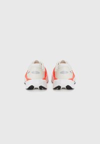 Sports shoes featuring a lightweight design with a white, orange, and black color scheme. Smooth texture and rubber sole with traction details.