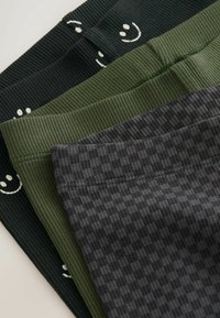 Trei perechi de leggings din țesătură ribbed în verde închis, verde măsliniu și gri antracit, având un design cu față zâmbitoare pe perechea de verde închis.