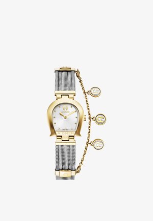 Guld- og sølvfarvet Aigner armbåndsur med hesteskoformet urkasse, mesh-rem og tre hængende runde vedhæng på en kæde.