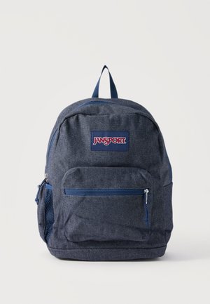 Zaino Jansport blu scuro con tasca frontale con cerniera e tasca laterale in rete, mostrato su uno sfondo chiaro uniforme.