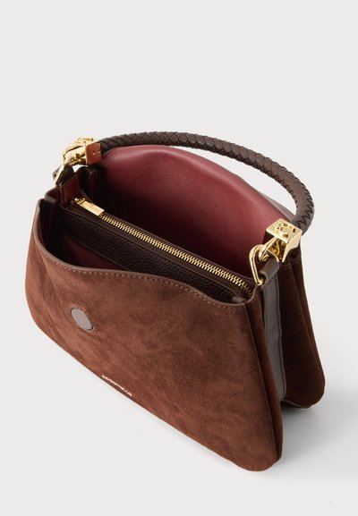 Sac à main ouvert en daim marron avec doublure bordeaux, compartiment intérieur zippé, poignée tressée et ferrures dorées.