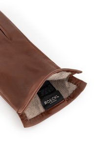 Brauner Lederhandschuh mit beigem gestricktem Futter, der das ROECKL München Markenetikett im Handgelenksbereich auf einem weißen Hintergrund zeigt.