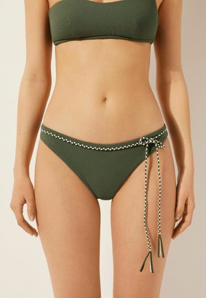 Ensemble de bikini vert en tissu texturé. Le haut est de style bandeau, et le bas comporte une sangle tressée décorative avec des gland.