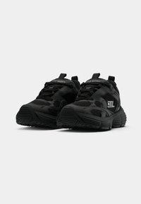 Pair of black Steve Madden athletic sneakers with mesh and synthetic overlays, thick soles, and pull tabs on a white background.