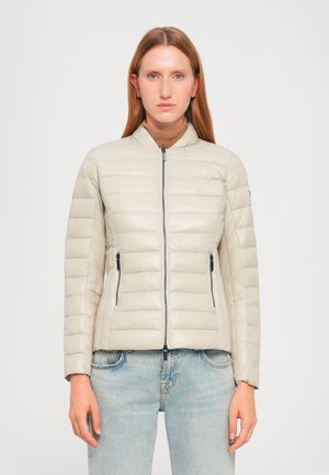 Gevoerde ritjack in lichtbeige met een doorgestikt ontwerp, staande kraag en zijzakken met rits. Glad textuur, getailleerde snit.