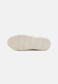Sneaker sole in white rubber, textured with diamond-shaped patterns and horizontal lines. Features brand name "LOVE MOSCHINO" embossed.