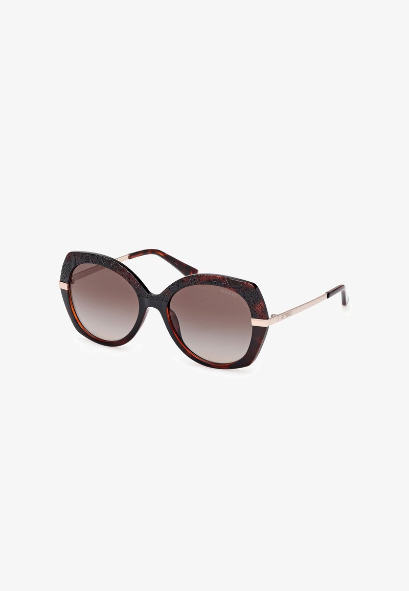 Tortoiseshell sunglasses with a wide cat-eye shape, gradient lenses, and textured detailing on the top frame. Metal accents at the temples.