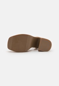 Brown rubber sole with horizontal ridges, featuring a rounded toe and a slight heel. No visible branding or patterns.