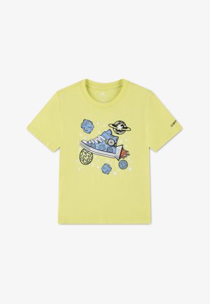 Geel T-shirt met een blauwe sneaker-rocket omgeven door planeten, sterren en elementen uit de ruimte, met het Converse-logo op de rechtermouw.