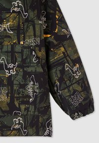 Padded jacket w ciemnozielonym kolorze z białymi i złotymi grafikami dinozaurów, w luźnym kroju i z elastycznymi mankietami. Napis zawiera "Strefa Dinozaurów" oraz "Raa!"