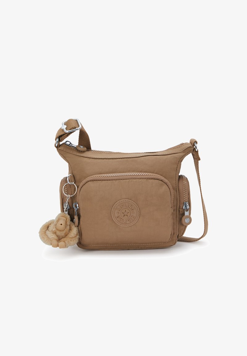 Borsa a tracolla marrone chiaro realizzata in tessuto morbido con una finitura testurizzata. Presenta una tasca frontale, chiusura con zip e un portachiavi a forma di scimmia in peluche.