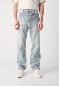 Világoskék farmerralfolyás halvány kopott hatással és finom függőleges csíkokkal. Egyenes szabással, öt zsebes kialakítással és zipzáras sliccel rendelkezik.