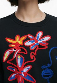 Sudadera negra con bordado floral colorido en rojo, azul, amarillo y blanco, con un acabado texturizado. Cuello redondo y diseño casual.