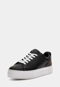 Sneaker in pelle nera con lacci bianchi, dotata di una suola bianca spessa e un accento decorativo marrone sul tallone embossato con un logo.