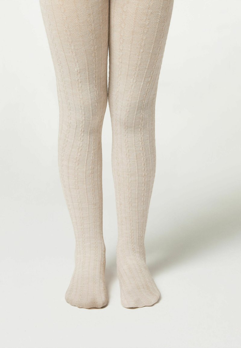 Beżowe rajstopy dziane z pionowymi prążkami, miękką teksturą i dopasowanym krojem, sięgające od talii do kostek.