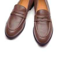 Mocassini in pelle marrone con finitura leggermente strutturata, dettaglio cucito sul gambetto e suola liscia, adatti per un abbigliamento formale.