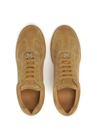 Sneaker in suede beige con punta rotonda, lacci piatti e accentuazione del logo metallico. Interno imbottito, dettagli testurizzati sulla tomaia.