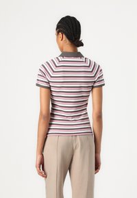Randig polo skjorta med korta ärmar, med rosa, grå och vita horisontella ränder och en grå krage. Slät tyg med en figurnära design.