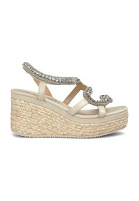 Sandale compensée beige avec une semelle en jute tressé, une bride ornée de strass et un dessus en synthétique lisse avec un design à bout ouvert.
