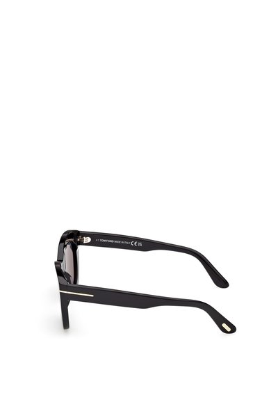 Occhiali da sole neri rettangolari con montatura spessa, caratterizzati da un accento in metallo dorato sul lato e una finitura liscia e lucida. Made in Italy.