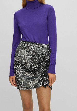 Suéter morado de cuello alto combinado con una falda negra cubierta de lentejuelas plateadas, con un borde rizado y una textura suave.