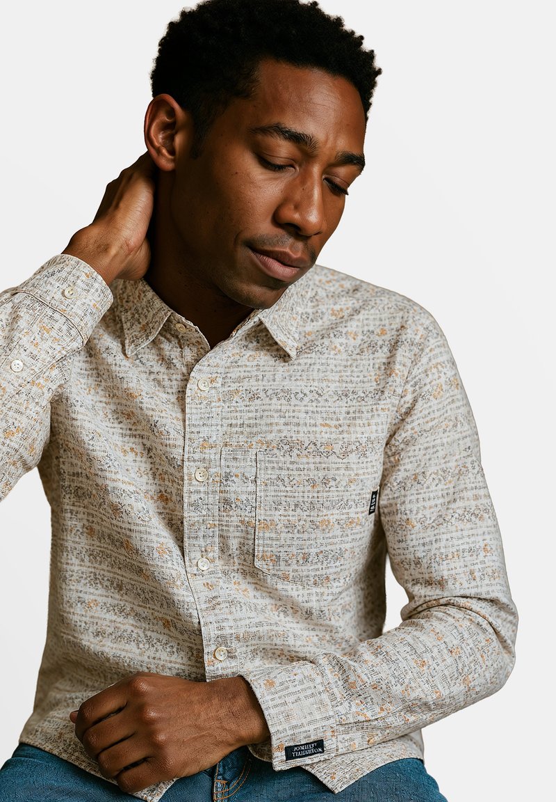 Lichtgekleurde button-up overhemd met een gestructureerd patroon in beigetinten en oranje, met een borstzak en ronde kraag.