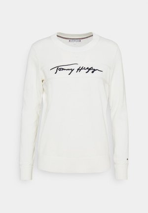 Hvid langærmet sweatshirt med rund halsudskæring og sort kursiv "Tommy Hilfiger" logo på brystet.