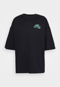 Svart oversized t-shirt i bomull, med en grön grafisk logotyp på bröstet. Kort ärm och rund halsringning.